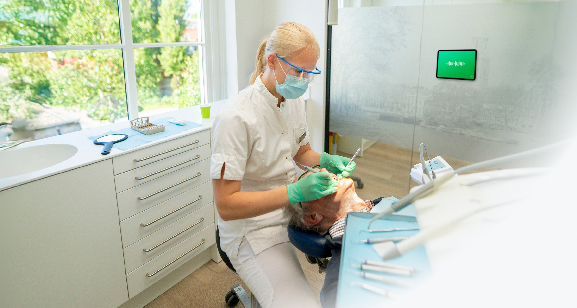 Dentist treating a patient while Sonobe listens ambiently in the treatment room